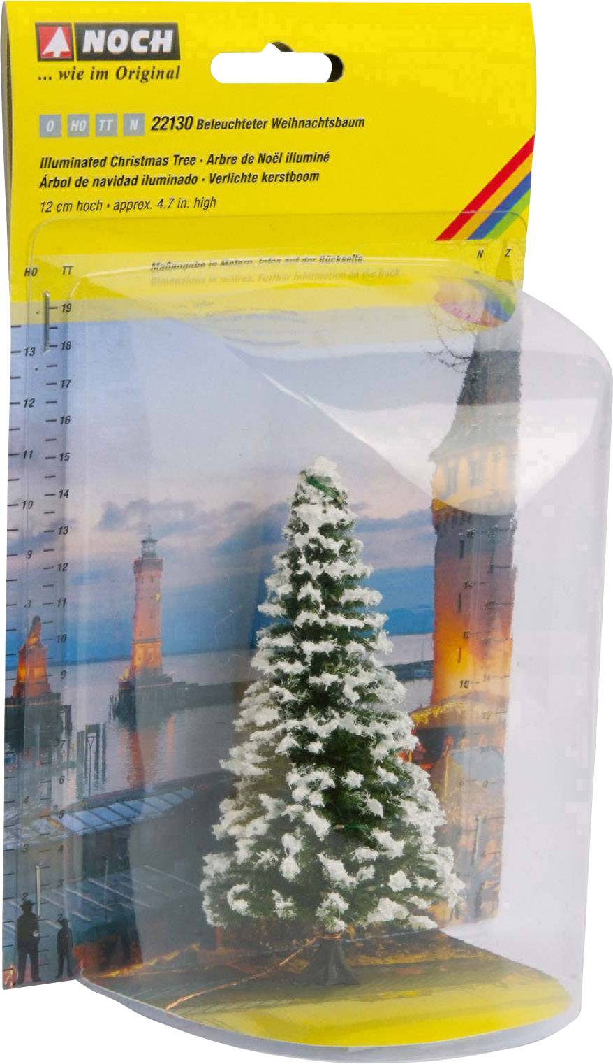 Illuminated miniature Christmas tree to scale, packaged in front of a background image of a castle at sunset.