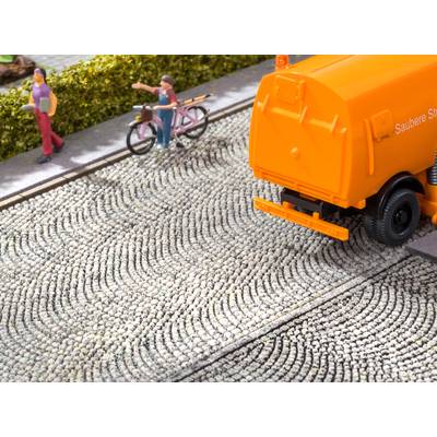 A small model depicts an orange street sweeper on a paved road, with two figures and a bicycle at the edge.