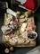 On a wooden board lies a selection of cold meats, sausages, olives and figs, surrounded by bread and crackers, with wine in the background.