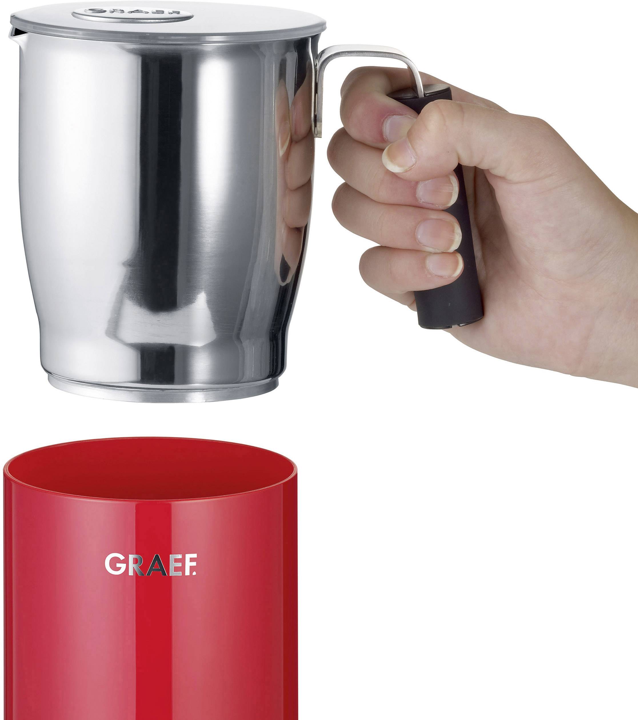 A hand is holding a silver milk frother jug over a red container. The red container is labelled 'GRAEF'.