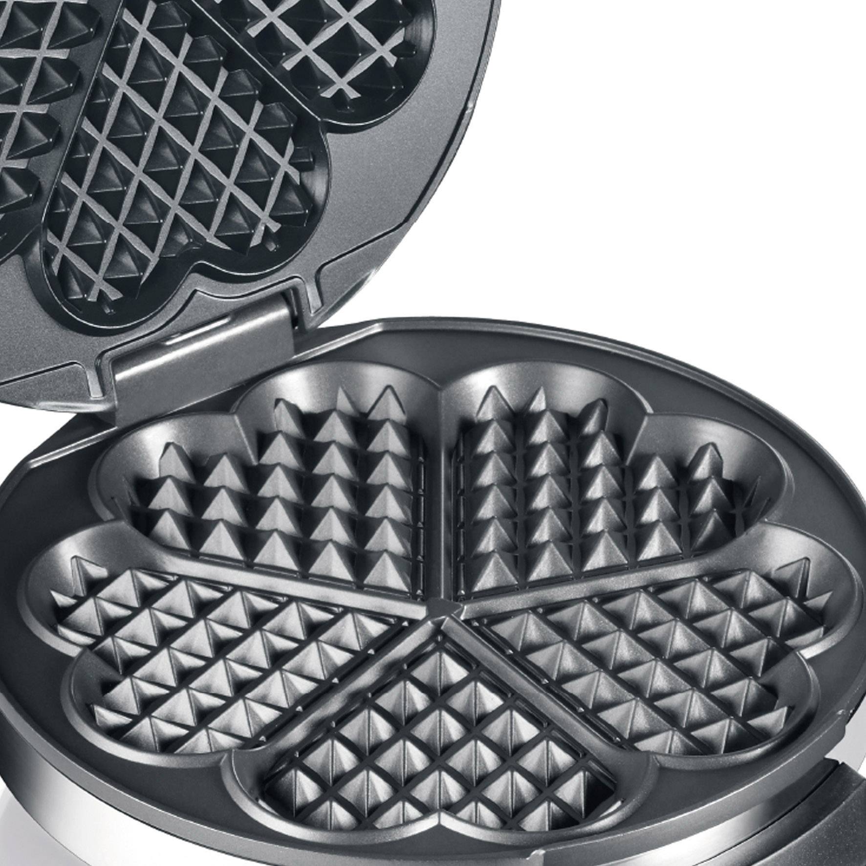 Waffle iron with heart-shaped, non-stick plates, opened and ready for baking.
