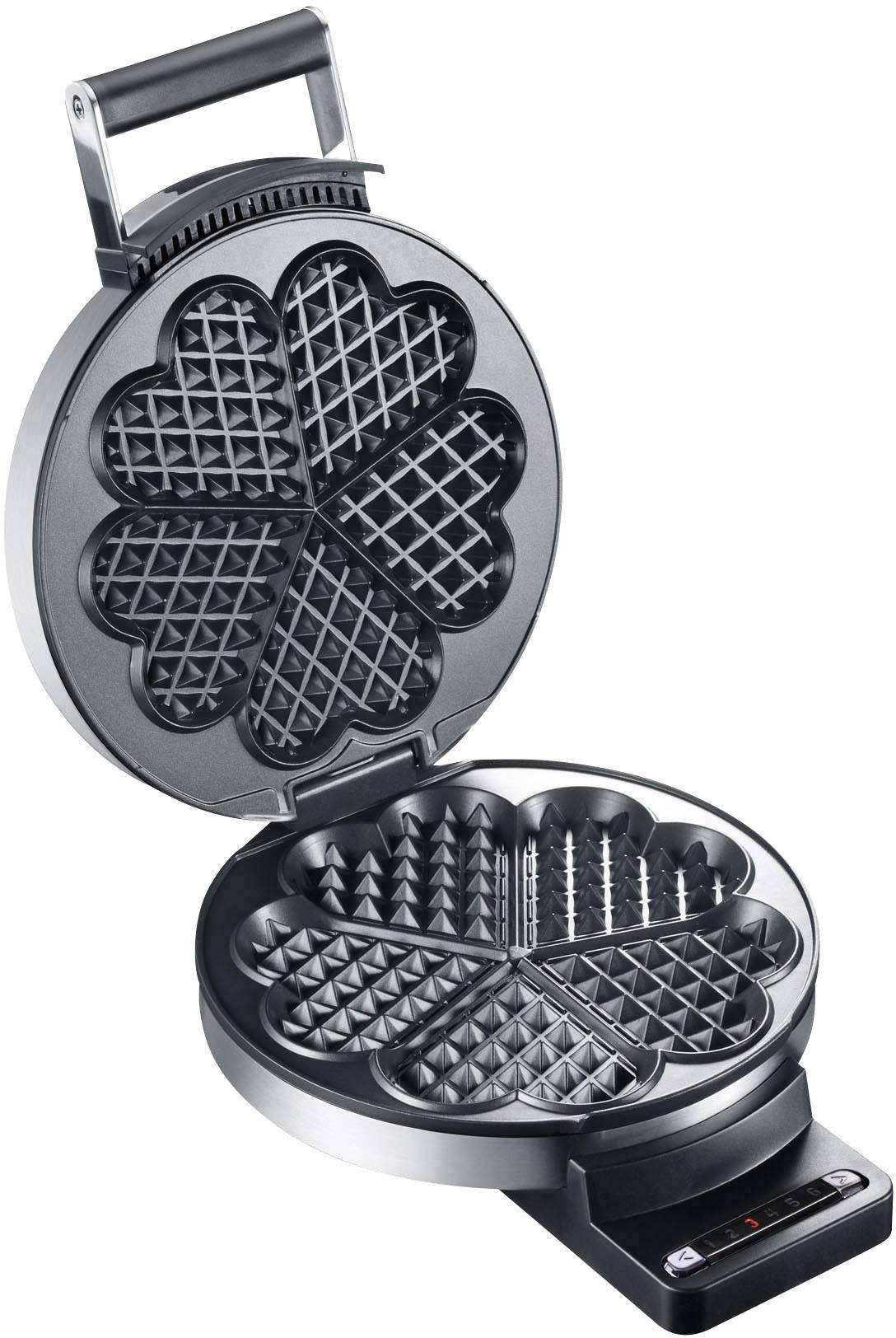 An open waffle iron with heart-shaped wells, ready for baking.