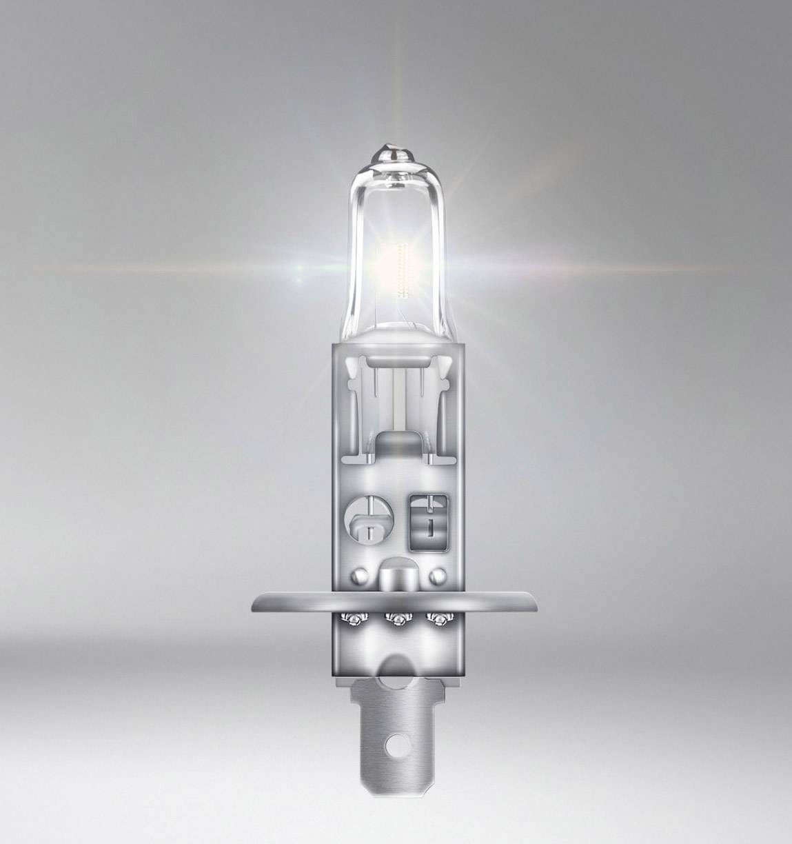 A bright halogen lamp with visible glowing filaments, surrounded by a radiant beam of light, against a grey background.