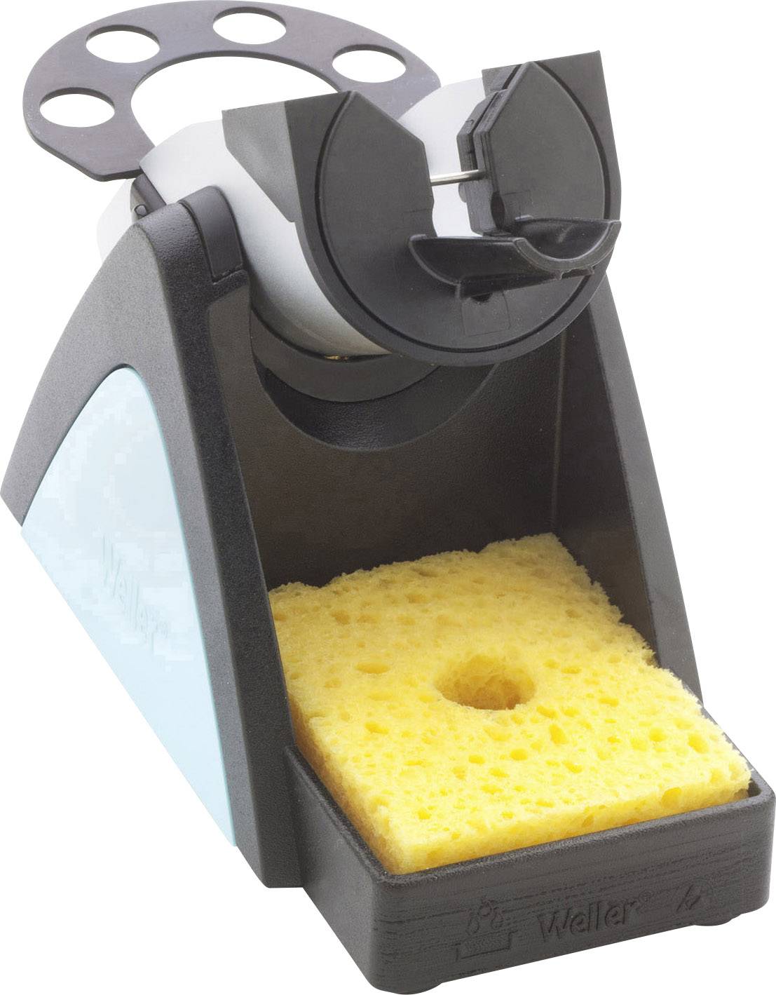 Soldering iron stand with cleaning sponge in the foreground. Black plastic housing with light blue accents.