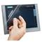A hand holds a SIMATIC HMI touchscreen and peels off a protective screen film.