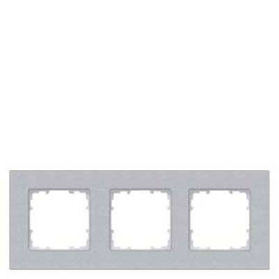 Triple metal frame in silver for light switches or sockets, arranged in a rectangular layout. Simple, modern design.