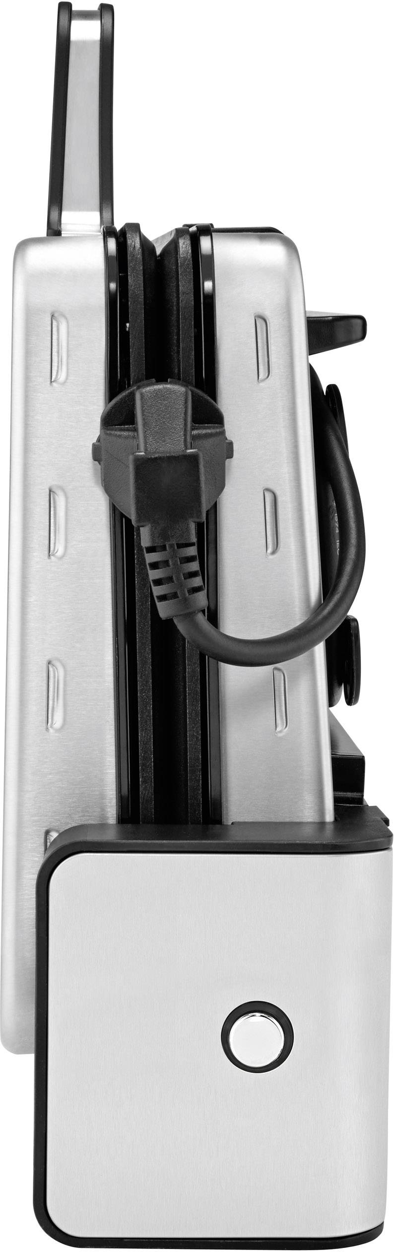 A folded silver sandwich maker turned on its side with a black handle. The power cord is wrapped around the handle.