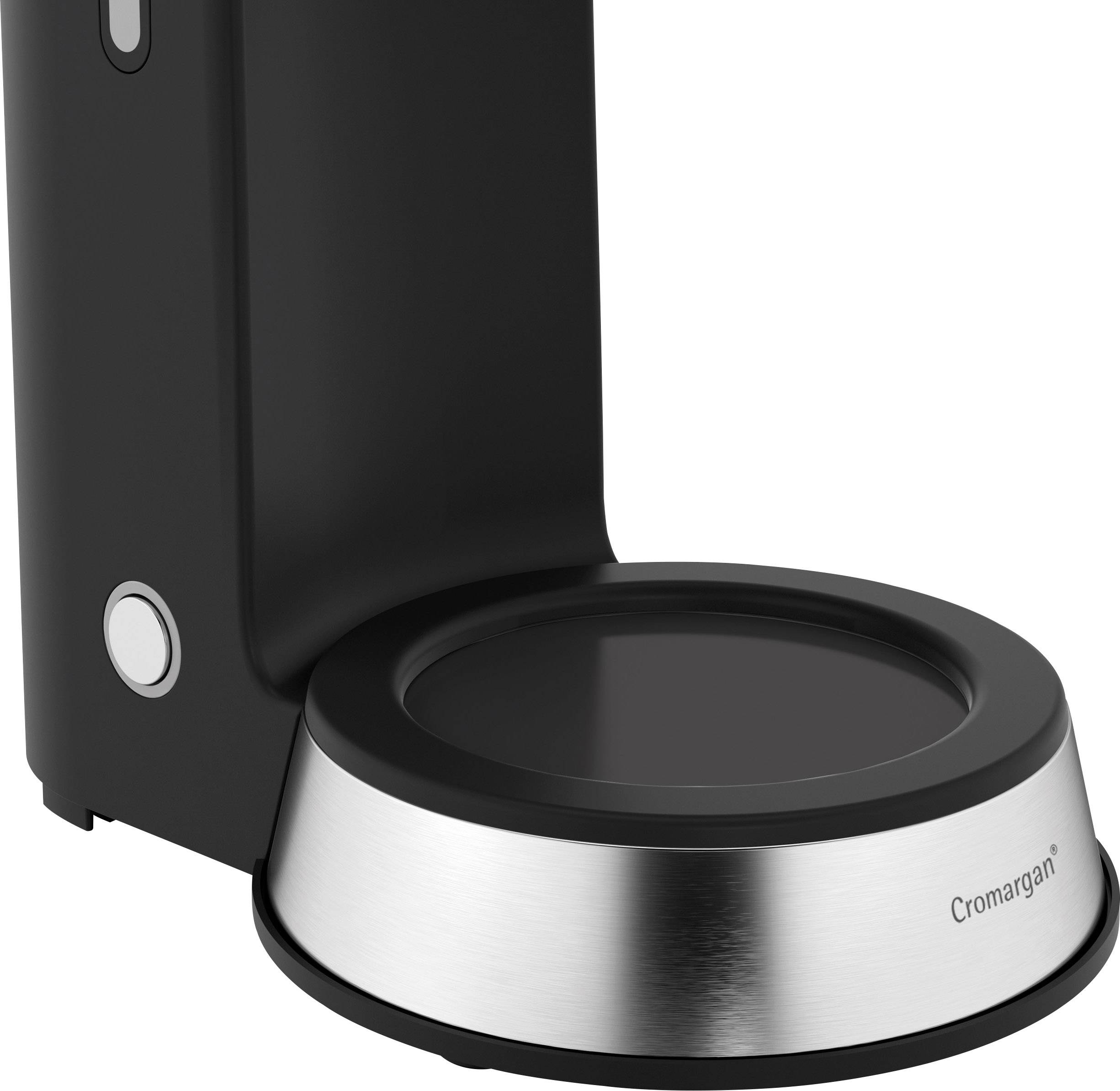 The image shows a black stand mixer or kitchen machine attachment with a chrome base.