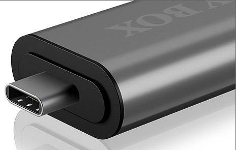 A black portable charger with a USB-C port, lying on a reflective surface.