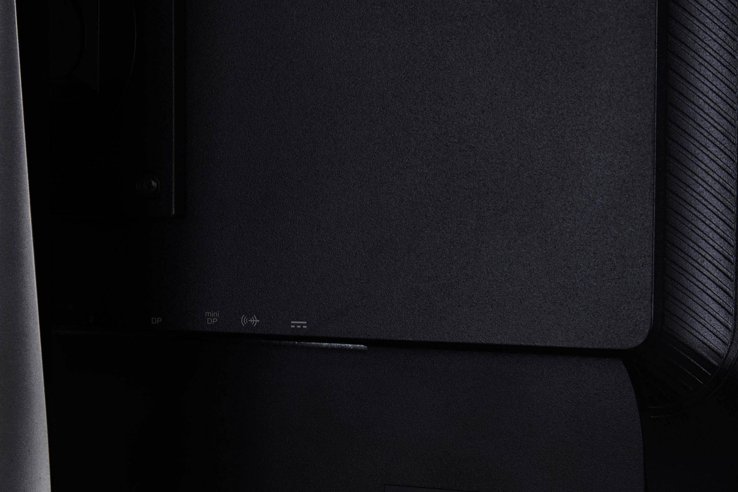 Dark grey, textured back panel of an electronic device. Contains symbols for power, headphones, HDMI and USB.