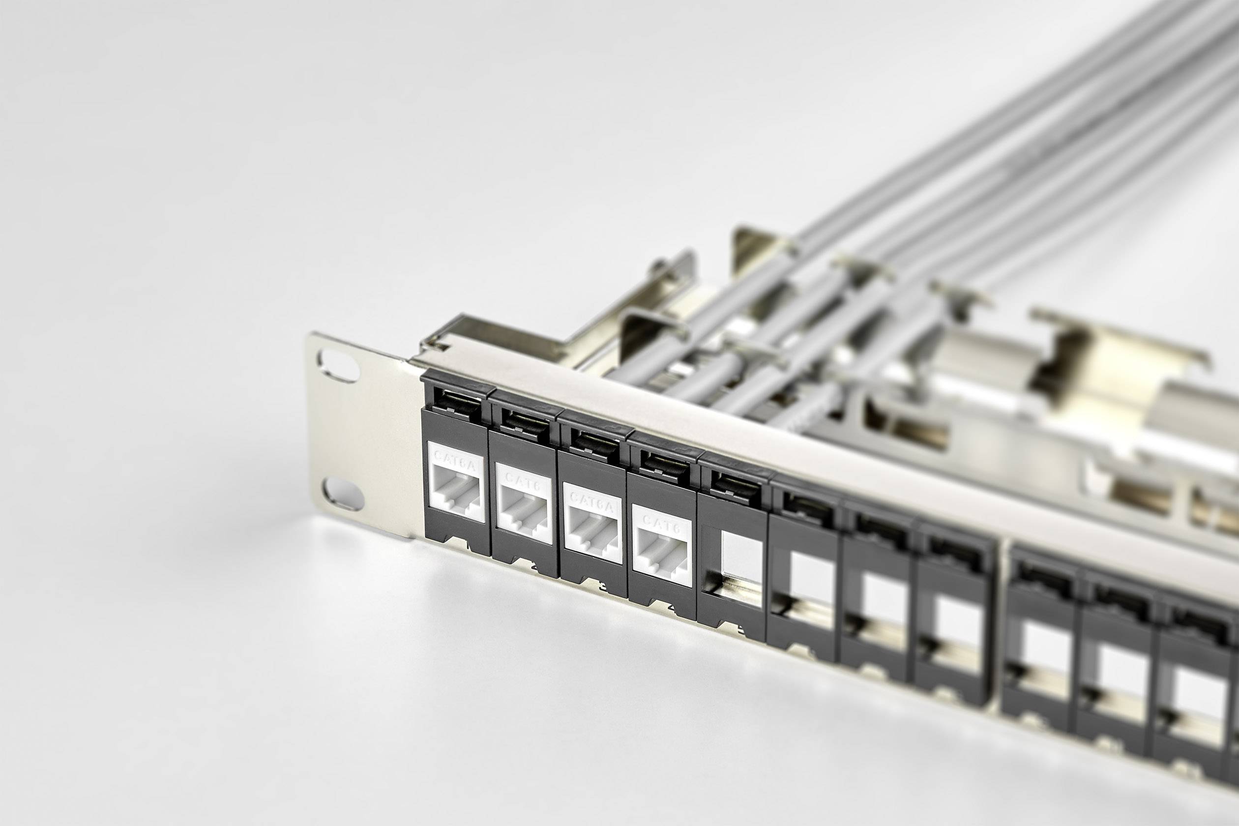 A network patch panel with multiple Ethernet ports and cables, mounted in a server rack, shows the cabling structure.