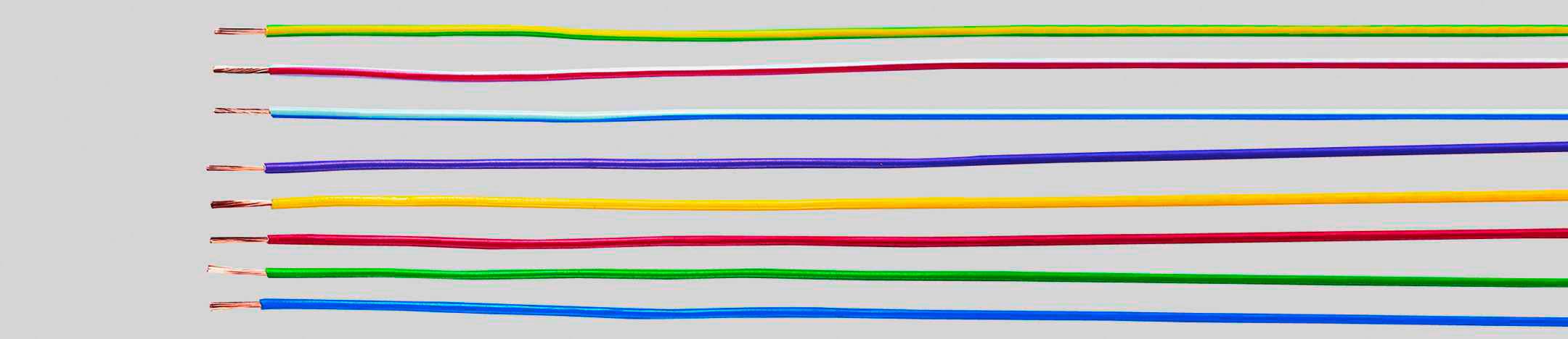 Eight differently coloured wires lie parallel to one another, shown from left to right on a grey background.
