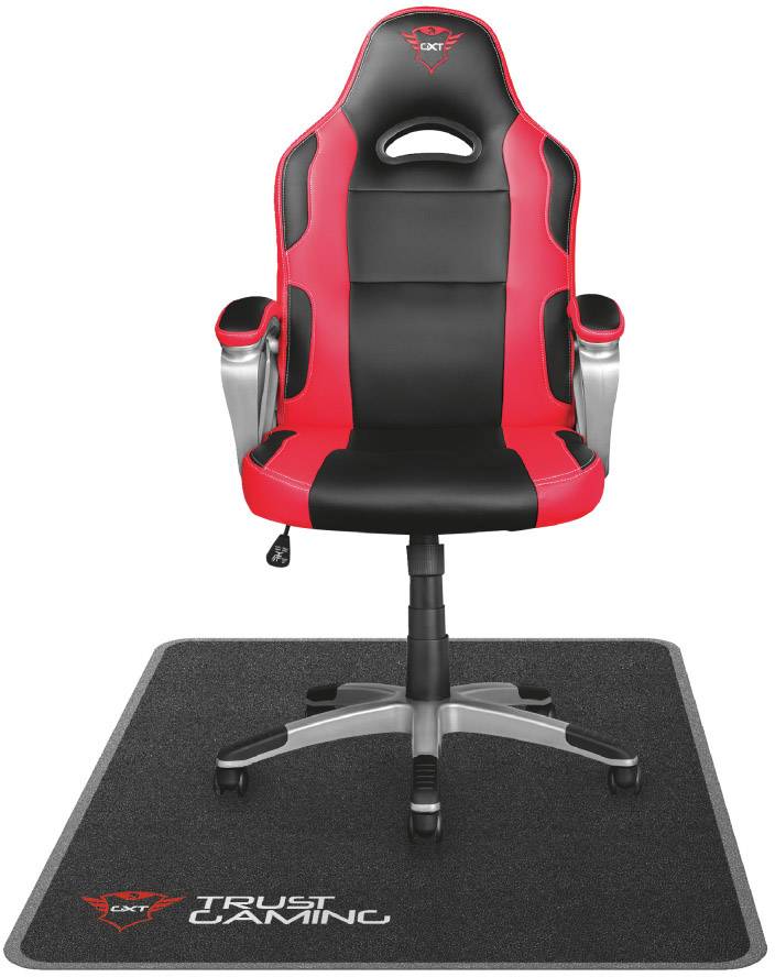 Red and black gaming chair on a carpet with 'Trust Gaming' logo, ergonomic design with armrests and neck support.