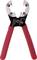 A wire stripper with serrated jaws, red handles, and a silver head, used for stripping electrical cables.
