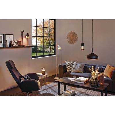 Cosy living room with an armchair, sofa and coffee table. Large windows allow light to flood in. Decorative pictures and lamps around the room.