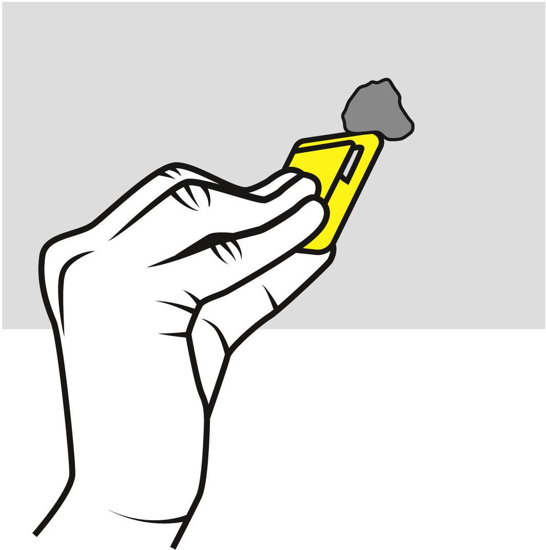 A hand holds a yellow device with a grey recognition attachment in the upper corner above a grey surface edge.