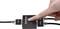 A hand is pressing the button on a black 'SpeaKa Professional' HDMI splitter connecting two HDMI cables.