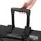 A hand pulls up the handle of a black rolling suitcase. The suitcase has sturdy, black handles and straps.