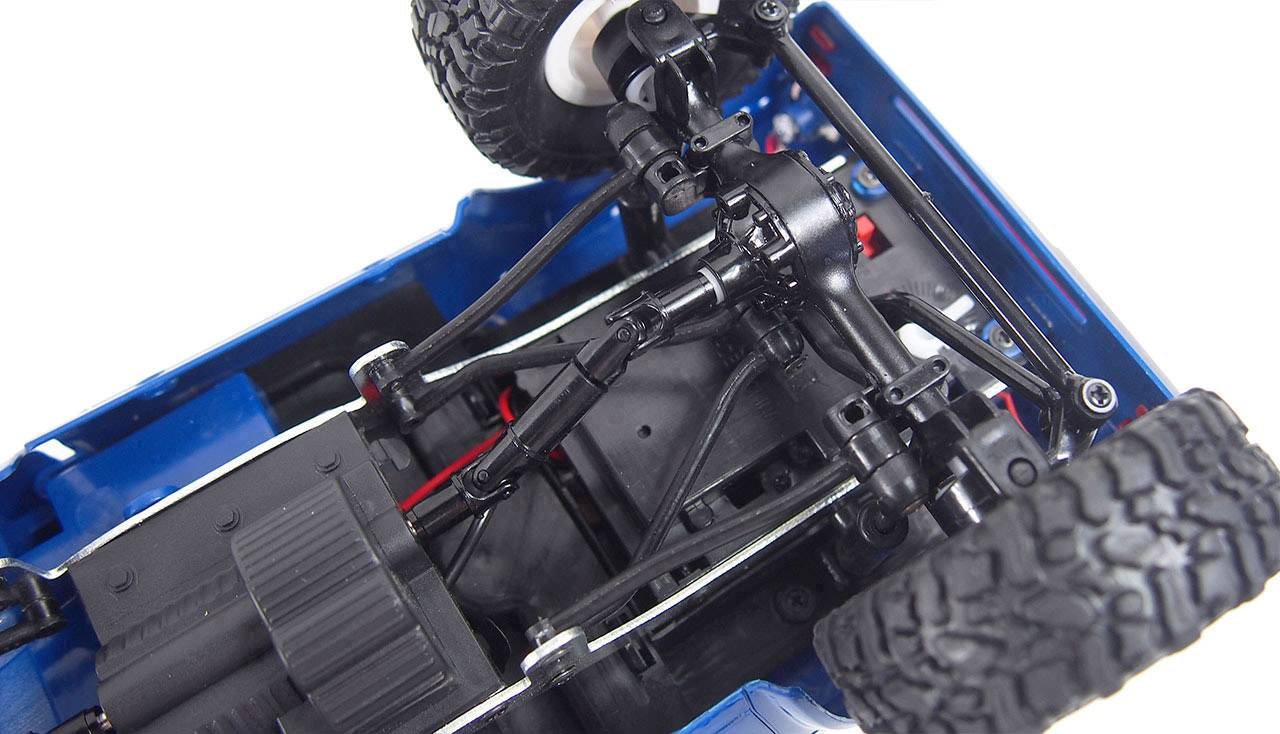 Close-up of the underside of a model car, revealing suspension and tyres, showing technical details and construction.