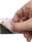 A hand removes the protective film from a self-adhesive 3M product in preparation for application.