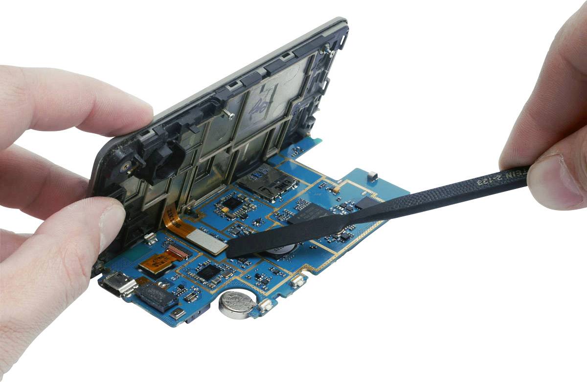 A hand opens a smartphone to expose its internal circuit board, using a tool for repair or analysis.