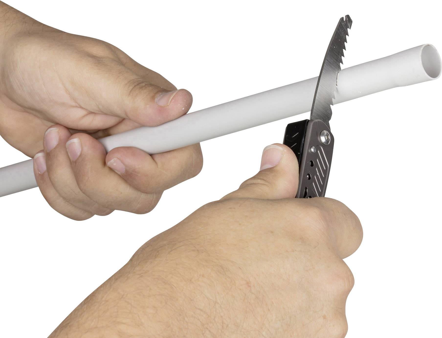 Hands are cutting a white plastic pipe with a penknife.