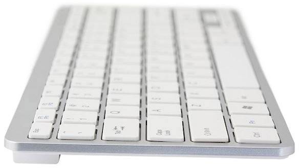 White, modern computer keyboard design with slim keys from a side perspective.