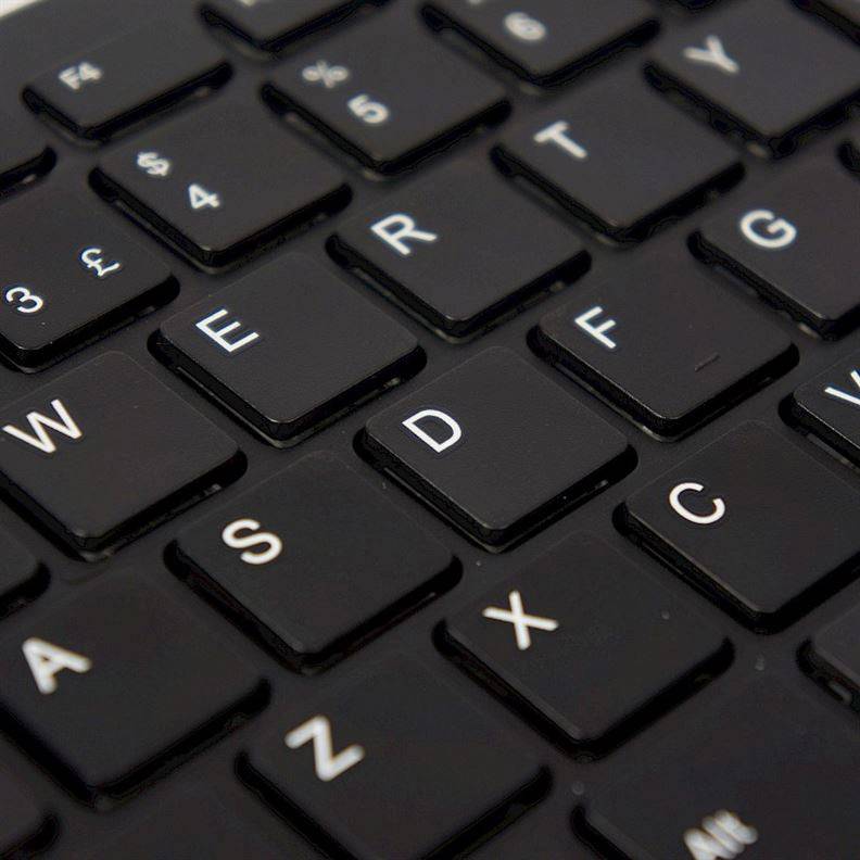 Close-up of a black computer keyboard with white letter keys in QWERTY layout.