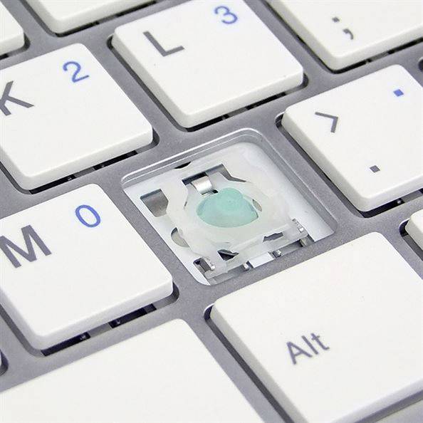 A computer keyboard with a missing key reveals an exposed switch mechanism.
