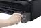 A hand pulls a black ink cartridge from a black printer.