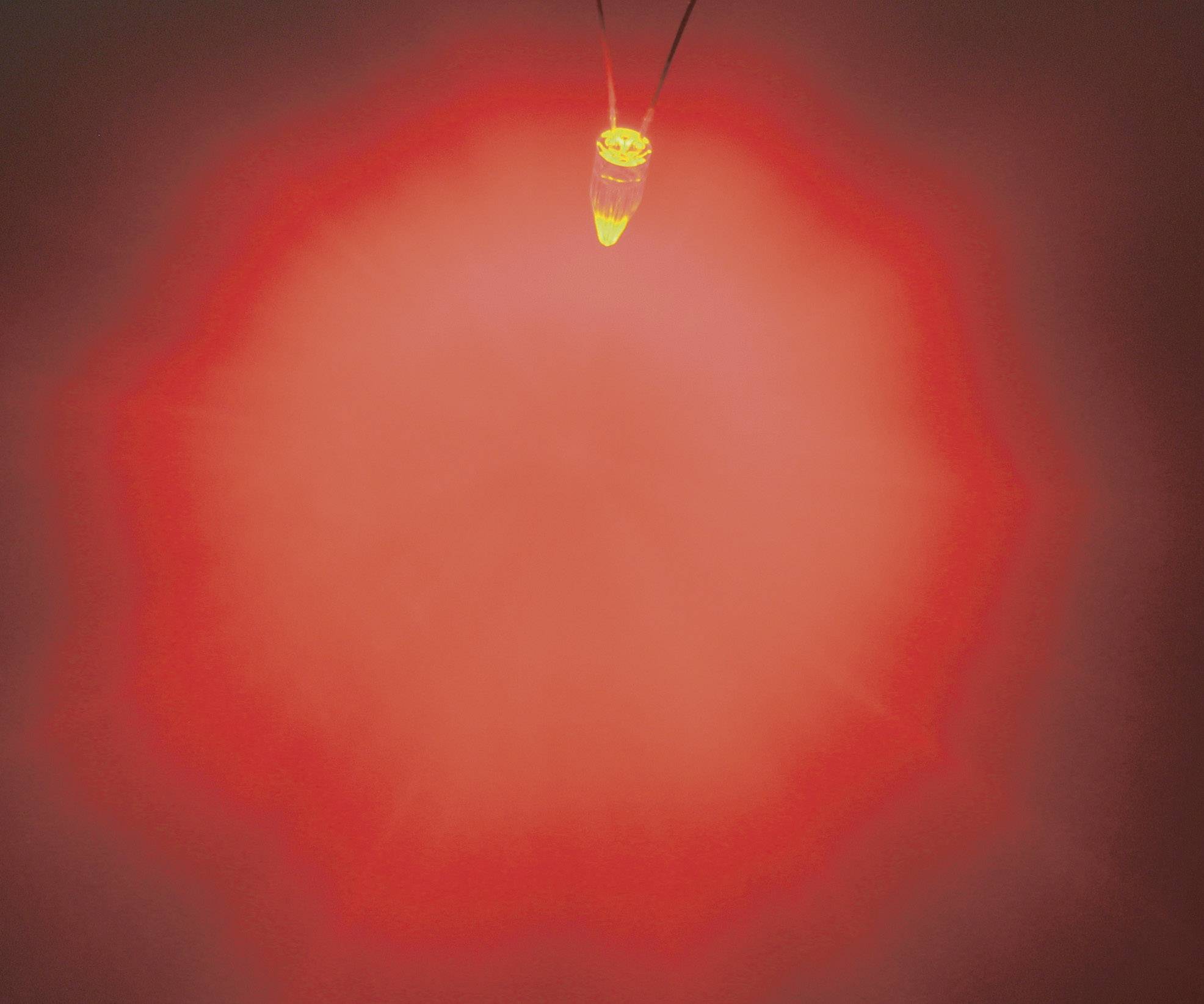 A red LED emits a bright, uniform light, creating a glowing, circular pattern on a surface.