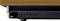 'Close-up of a black, rectangular base with ventilation slots underneath a wooden table; the base's feet are visible.'