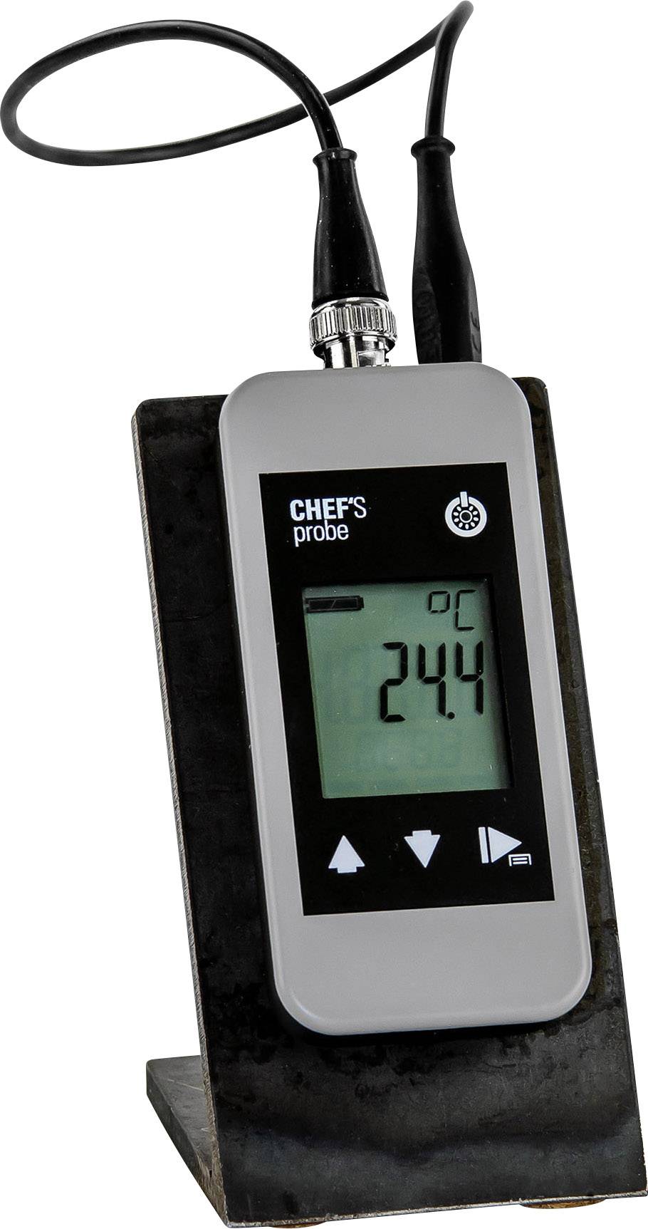 A digital thermometer is displaying a temperature of 24.4 degrees Celsius. It is situated in a black holder and has two cables.