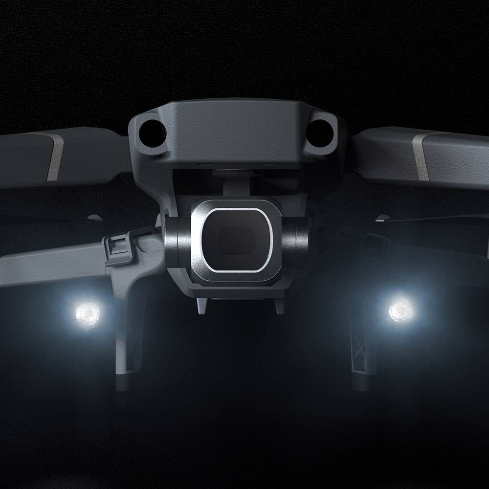 Close-up of a drone with illuminated headlamps against a dark background, conveying technical details and modernity.