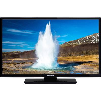 A television shows the image of an erupting geyser against a mountainous landscape under a blue sky.