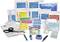 First aid kit with bandages, plasters, scissors, tweezers and cool packs, arranged on a table.