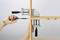 A person is securing a wooden shelf with two G-clamps and a screwdriver.
