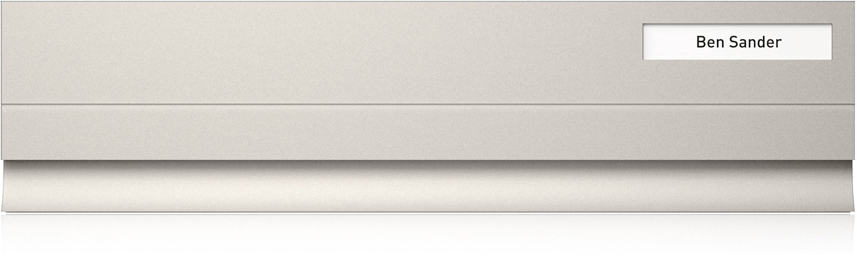 Metallic surface of an office desk with a name plate reading 'Ben Sander' in the top right corner.