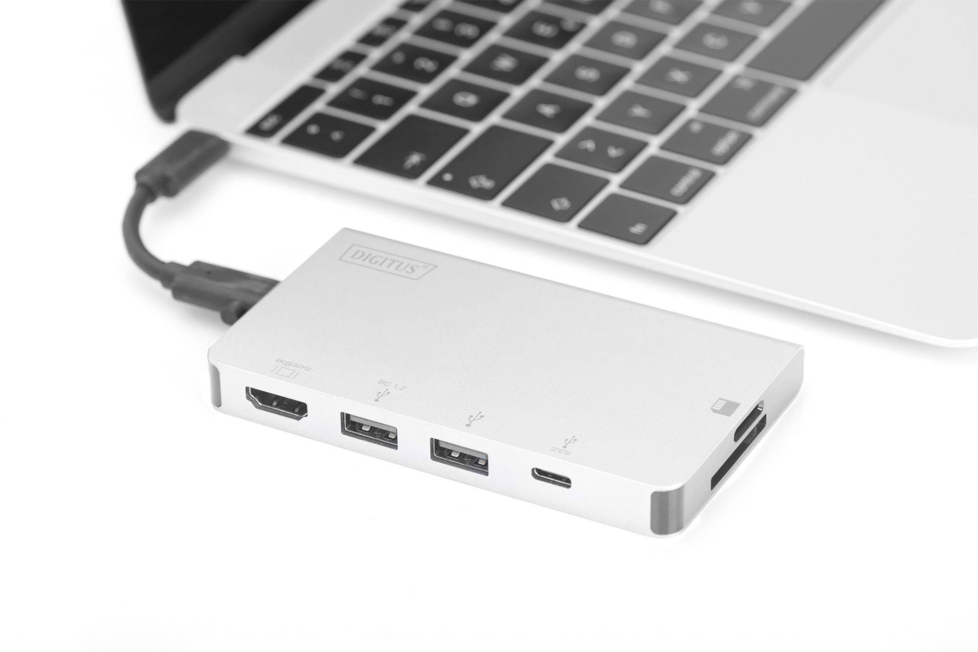 Laptop with connected USB hub. The hub has multiple ports, including HDMI and USB. The laptop is partially visible.
