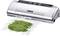 A vacuum sealer seals a bag of green beans airtight. The device has a silver casing with control buttons on top.