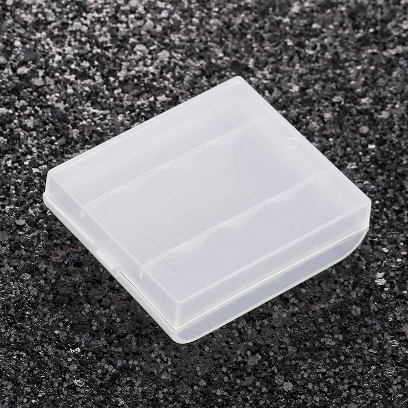 A transparent, square plastic box is resting on a rough, dark surface.