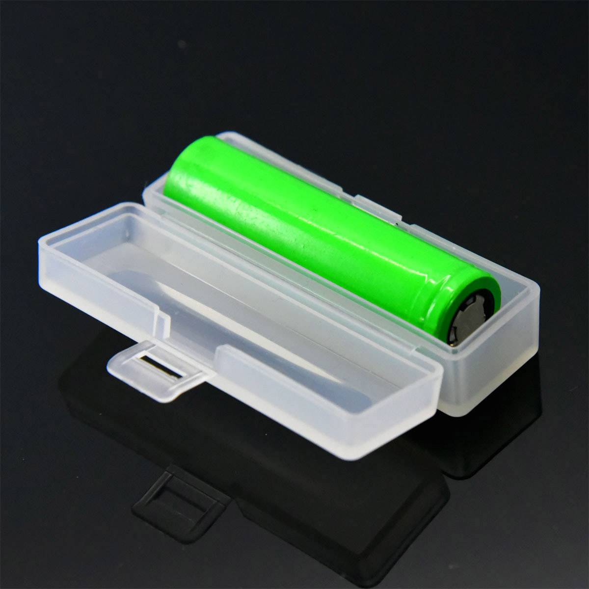 Green battery in a transparent plastic box on a dark background.
