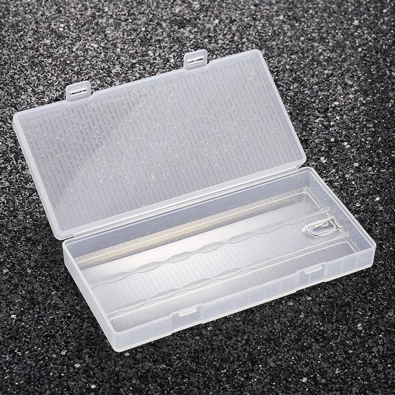 An open, transparent plastic container on a dark, textured background, empty and ready for storing items.