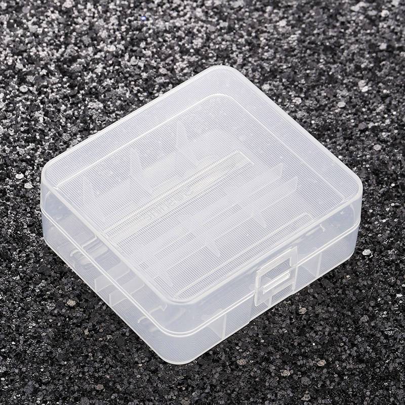 'Transparent plastic storage box with multiple compartments, resting on a black, grainy background.'