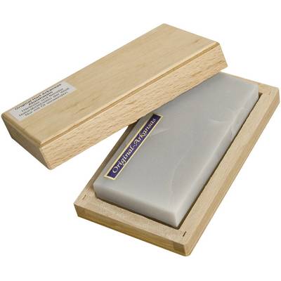 A whetstone lies in an open wooden box. A label on the stone reads 'Original Arkansas'.
