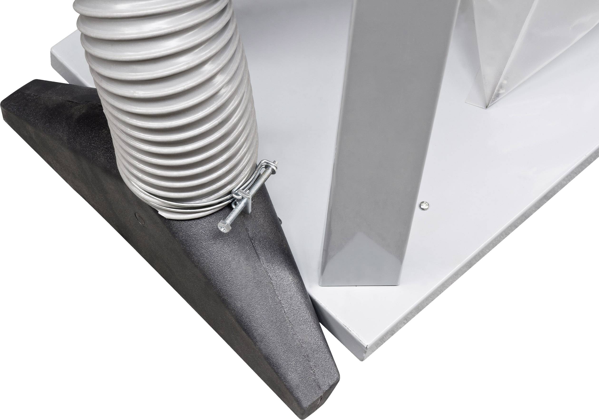 A black rubber wedge secures a flexible grey hose to a silver mechanical structure on a white base.