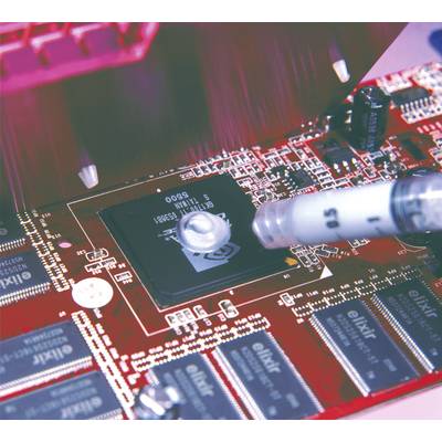 Close-up of a printed circuit board where paste is being applied to a chip. The board displays various electronic components and circuit traces.
