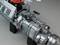 Close-up of a machine engine with visible metal components and cables. The motor is mounted on black brackets.