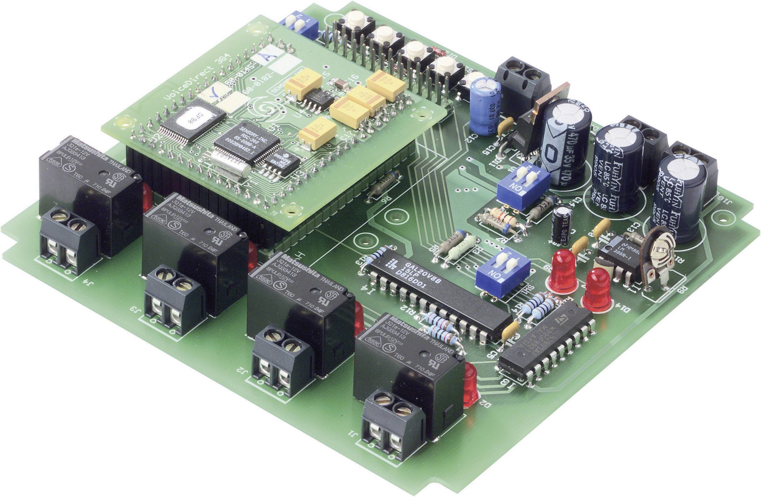 A green electronic circuit with multiple relays, resistors, and large blue capacitors. A microcontroller module is mounted in the top left.