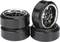 Four black toy car wheel rims with shiny, silver hubcaps, two stacked on the left and two standing on the right.